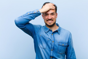 young handsome man panicking over a forgotten deadline, feeling stressed, having to cover up a mess...