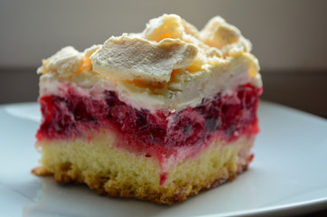 Closeup of cookies with raspberries, cream and meringue on a plate