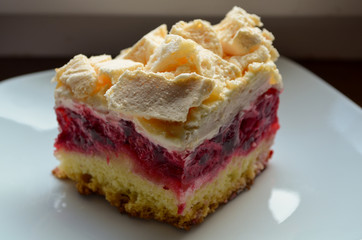 Closeup of cookies with raspberries, cream and meringue on a plate