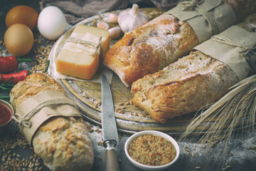 Bread in a composition with kitchen accessories on an old background