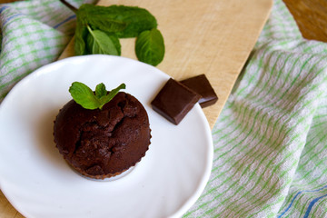 Top View of Chocolate Muffin with Mint Leaves on the Saucer in the Kitchen