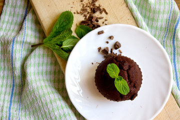 Top View of Chocolate Muffin with Mint Leaves on the Saucer in t