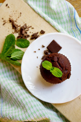 Top View of Chocolate Muffin with Mint Leaves on the Saucer in t