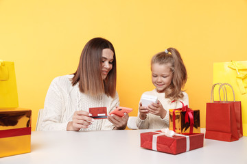 Happy mother and daughter with presents. Pretty family in the New year concept