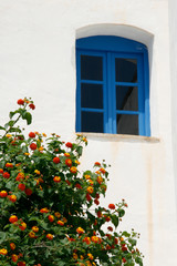 Fototapeta na wymiar window in front of the house wall. Specific vintage scene in Greece, Mediterranean.