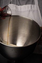 Vanilla is poured into a metal bowl for a recipe