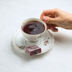 White porcelain tea cup on a white background in womans hands