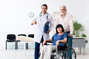 Old couple visiting young male doctor