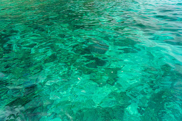 Fototapeta na wymiar Stone in the emerald blue water in the sea.