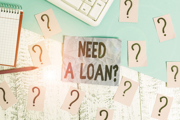 Text sign showing Need A Loan Question. Business photo showcasing asking he need money expected paid back with interest Writing tools, computer stuff and math book sheet on top of wooden table