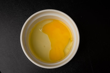 Raw eggs sit in a bowl to be added to a recipe