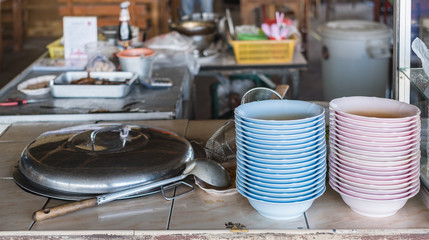 Vertical column stack of pink and blue plastic bowl at Thai local restaurant.