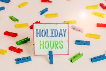 Word writing text Holiday Hours. Business photo showcasing employee receives twice their normal pay for all hours Colored clothespin papers empty reminder white floor background office