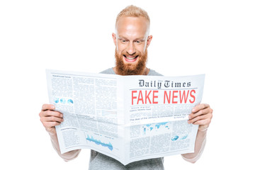 laughing bearded man reading newspaper with fake news, isolated on white