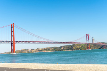 Red bridge, Lisbon, Portugal. Ponte 25 de Abril Suspension Bridge over the Tagus river. city background.