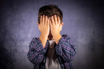 Little child covering his eyes with his hands