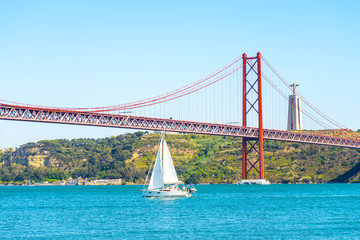 Red bridge, Lisbon, Portugal. Ponte 25 de Abril Suspension Bridge over the Tagus river. city background.