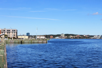 Fototapeta na wymiar Looking out over Halifax Harbour, Halifax, Nova Scotia, Canada. Partial view of dock in foreground.