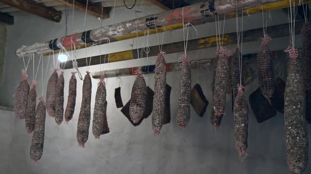 traditional Italian homemade salami salumi cured meat, cold cuts, pancetta , lard, bacon hung to mature ageing dry in the cellar