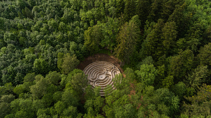 Aerial view of a maze in a park in the middle of a lush forest.
