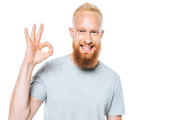 smiling man in grey t-shirt showing ok sign, isolated on white