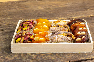 Sweet natural turkish delight background with dried apricots, figs, walnuts, pistachios and almonds on a rustic wooden background