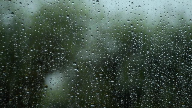 Rain water drops Falling Down On the Window Glass in slow motion