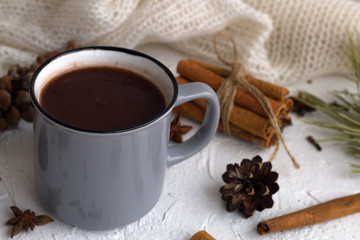 grey cup of hot chocolate and cinnamon, anise star with pine cone and green spruce branch on white background. horizontal. winter and autumn hot drinks