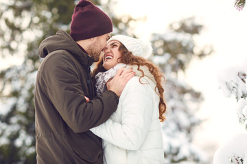 Fototapeta premium Man and woman kissing in snowy forest