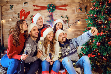 Laughing friends on Christmas party taking selfie