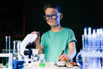 Child doing chemical research in laboratory. Dangerous experiment