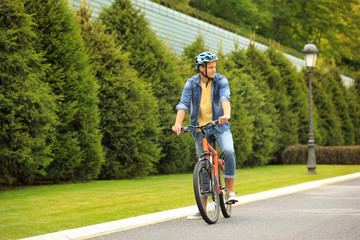 Young man in helmet riding bike outdoors