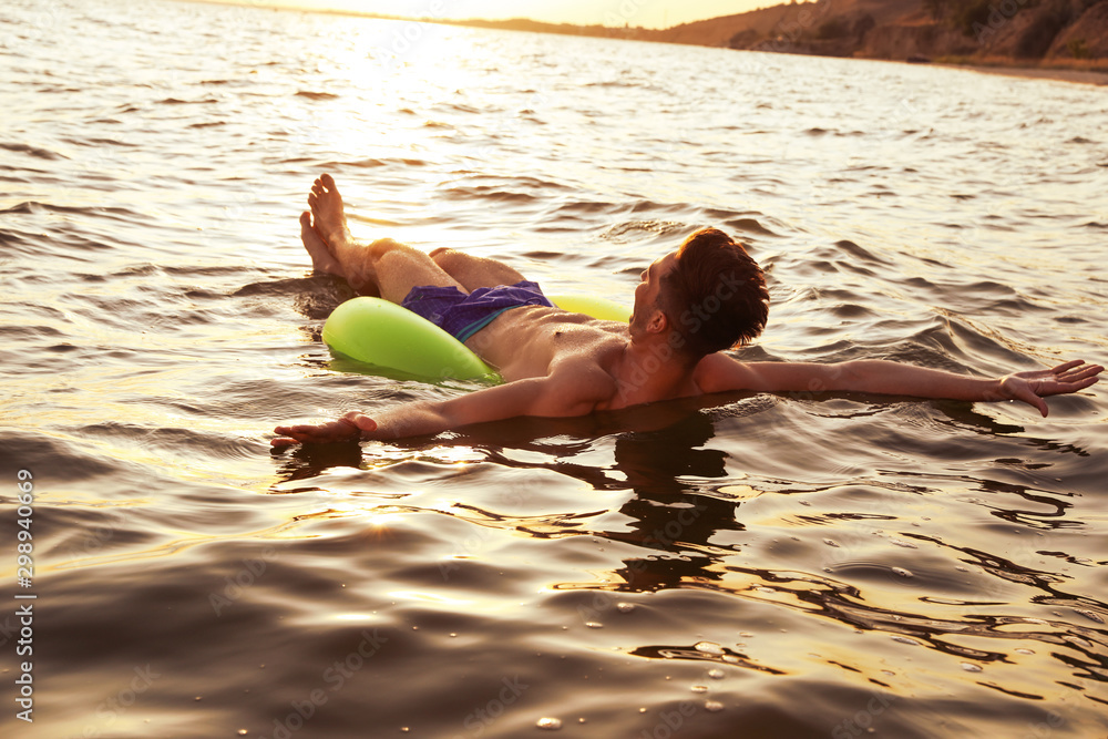 Canvas Prints Young man with inflatable ring in sea