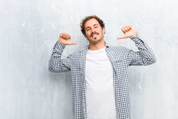 young handsome man feeling proud, arrogant and confident, looking satisfied and successful,...