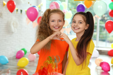 Happy children at birthday party in decorated room