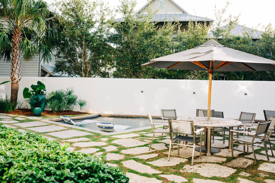 Modern Beach House Backyard With Pool, Table, And Umbrella