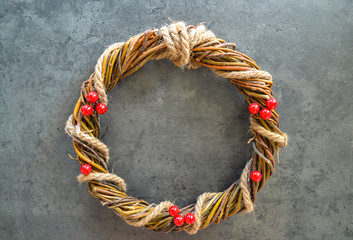 Homemade christmas wreath with holly berries. Braided Easter wreath with jute rope.