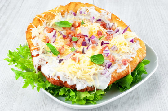 Langos with bacon and cheese - Hungarian fried dough food.
