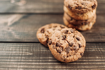 A stack of chocolate chip cookies lies on a wooden table. Rustic table. Vintage toning. Dietary...
