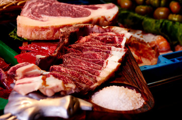 Fresh beef steake on a wood tray with salt.
