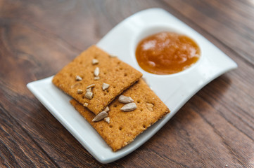 wheat crackers shooted with different  vegetables,groats,honey,seeds,salt on different surfaces