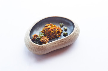 Rice food with greens on a stone plate on white cloth
