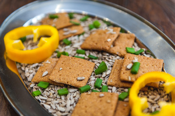 wheat crackers shooted with different  vegetables,groats,honey,seeds,salt on different surfaces