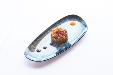 Salmon tartare food on a shape plate with sauce on a white cloth