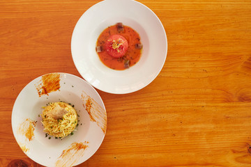 Grated potato dish with fish and peeled potato soup with fish broth on a wood table