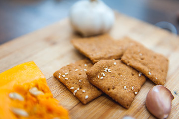 wheat crackers shooted with different  vegetables,groats,honey,seeds,salt on different surfaces