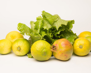 Bodegón de productos de otoño, lechuga, limones y granadas; productos sanos y llenos de...