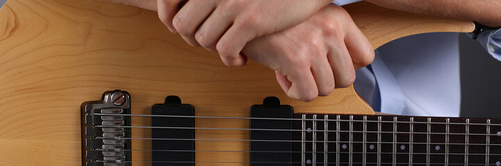Male arms playing classic shape electric guitar