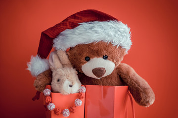 Christmas card with Teddy and banny in red gift bags.  With  holiday decoration and presents