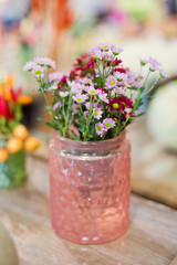 Fototapeta na wymiar Beautiful autumn seasonal flowers in pink glass vase
